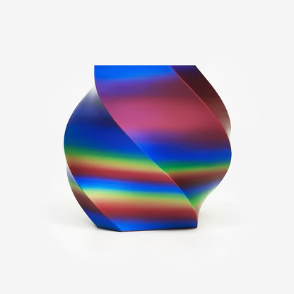 Twisted vase 3D printed with EIBOS Artism Series II Ribbons PLA in red, yellow and blue, showing its glossy striped colour effect.