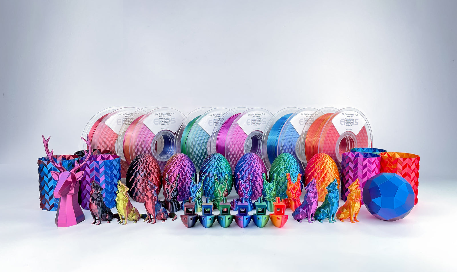 EIBOS Silk Series dual- and tri-colour PLA filament spools with colourful silk 3D-printed dragons, wolves, vases and eggs.